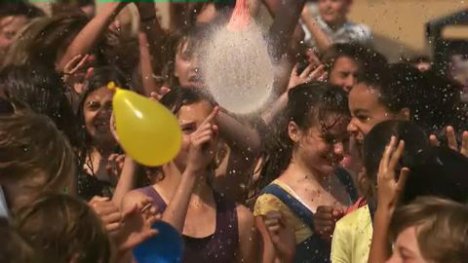 Water balloons burst over a group of girls for a Schweppervescence ad