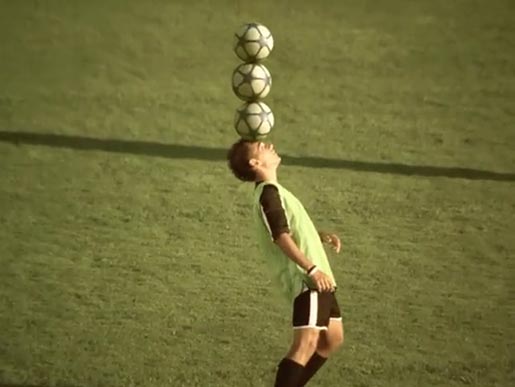 Brazilian football player balances three balls