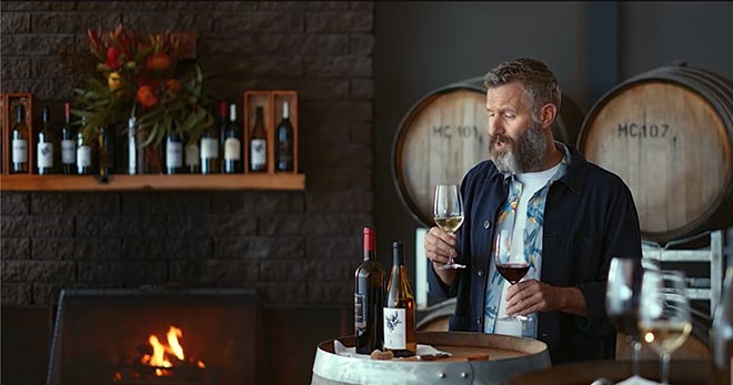 Adam Hills with wine in Tourism Australia Matesong